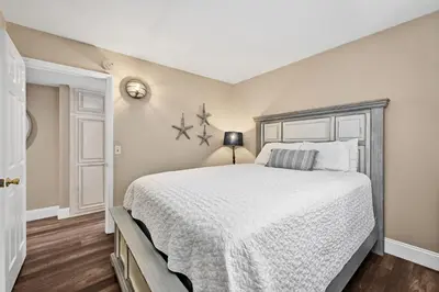a bedroom with a large bed with a white bedspread at Newport Paradise - Oceanfront Home by the Pier in Newport Beach