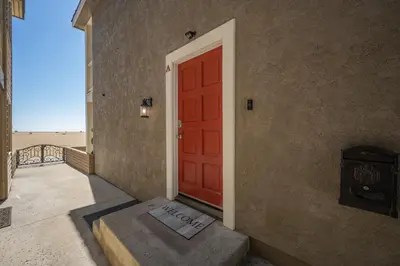a red door with a view of the beach at Newport Paradise - Oceanfront Home by the Pier in Newport Beach
