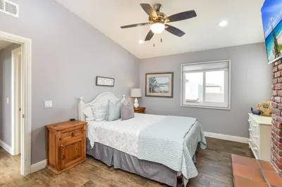 a bedroom with a bed and a ceiling fan at 5 Bedroom Home with Pool Table steps to the Beach in Newport Beach