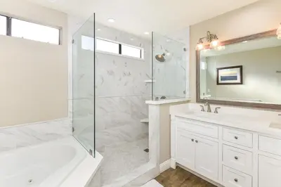 a bathroom with a shower and a tub and a sink at 5 Bedroom Home with Pool Table steps to the Beach in Newport Beach