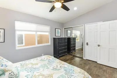 a bedroom with a bed and a ceiling fan at 5 Bedroom Home with Pool Table steps to the Beach in Newport Beach