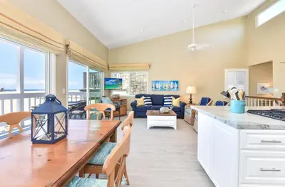 a kitchen and living room with a table and a couch at Multi Level Oceanfront Home with Patio on the Beach, Fire pit and 2 car garage in Newport Beach