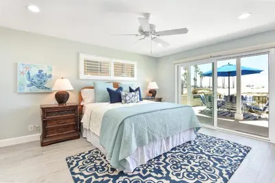 a bedroom with a bed and a window with a patio at Multi Level Oceanfront Home with Patio on the Beach, Fire pit and 2 car garage in Newport Beach