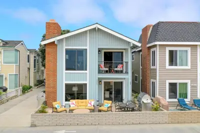 a house with a patio with chairs and a table at 3 Bedroom Home in Balboa - Walk to Pier & Restaurants in Newport Beach