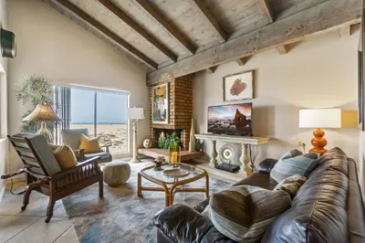 a living room with a couch and a fireplace at 2 Bedroom Home on the Beach with Ocean View in Newport Beach