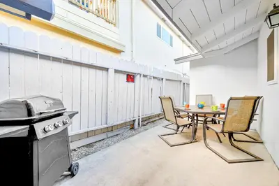 a patio with a table and chairs and a grill at Cozy 3 Bedroom Across from Playground on the Beach in Newport Beach