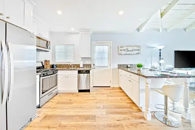 a kitchen with white appliances and a wooden floor at Cozy 3 Bedroom Across from Playground on the Beach in Newport Beach