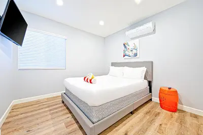 a bedroom with a bed and a flat screen tv at Cozy 3 Bedroom Across from Playground on the Beach in Newport Beach