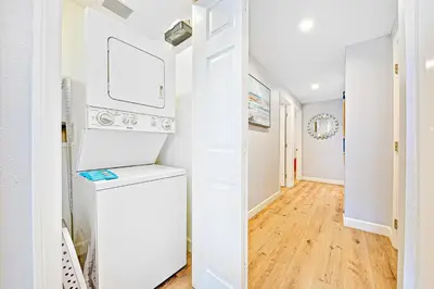 a hallway with white walls and hardwood floors at Cozy 3 Bedroom Across from Playground on the Beach in Newport Beach