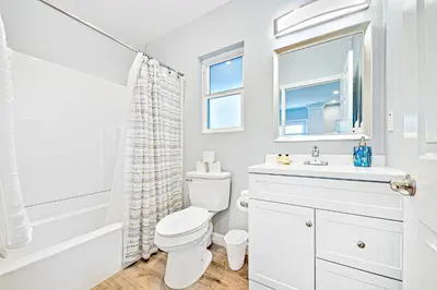 a white bathroom with a toilet and a sink at Cozy 3 Bedroom Across from Playground on the Beach in Newport Beach