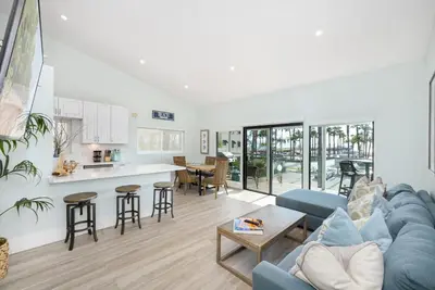 a living room with a blue couch and a table at 3 Bedroom home on the beach steps from Balboa Pier in Newport Beach