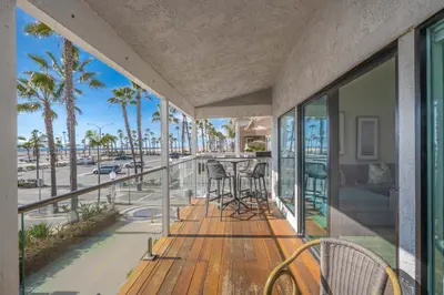 a balcony with a view of the beach and palm trees at 3 Bedroom home on the beach steps from Balboa Pier in Newport Beach