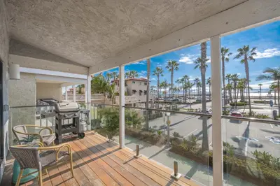 a balcony with a grill and palm trees at 3 Bedroom home on the beach steps from Balboa Pier in Newport Beach