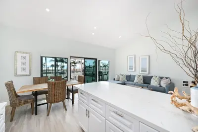 a kitchen and dining room with a table and a couch at 3 Bedroom home on the beach steps from Balboa Pier in Newport Beach