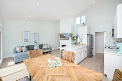 a kitchen and living room with a wooden table and a dining room at 3 Bedroom home on the beach steps from Balboa Pier in Newport Beach