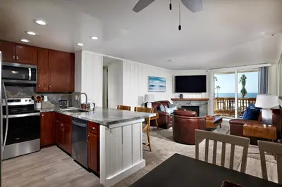 a kitchen and living room with a view of the ocean at Oceanside Beach Condos in Oceanside