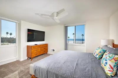 a bedroom with a bed and a flat screen tv at Oceanside Beach Condos in Oceanside