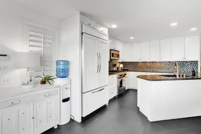 a kitchen with white cabinets and a white refrigerator at Fantastic bayside vacation home - WiFi, central AC, patio, private washer & dryer in San Diego