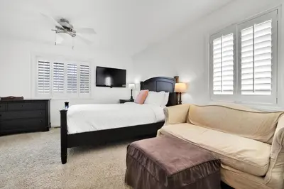 a bedroom with a bed and a couch and a tv at Fantastic bayside vacation home - WiFi, central AC, patio, private washer & dryer in San Diego