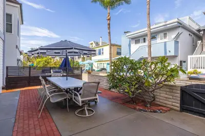 a patio with a table and chairs and an umbrella at Fantastic bayside vacation home - WiFi, central AC, patio, private washer & dryer in San Diego