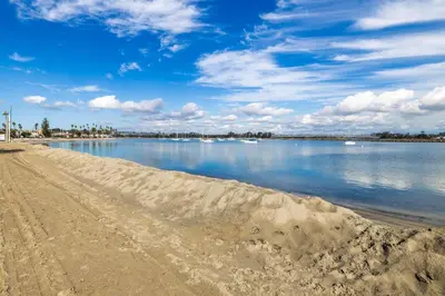 a sandy beach with boats in the water at Fantastic bayside vacation home - WiFi, central AC, patio, private washer & dryer in San Diego