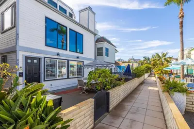 a white house with blue windows and plants at Fantastic bayside vacation home - WiFi, central AC, patio, private washer & dryer in San Diego