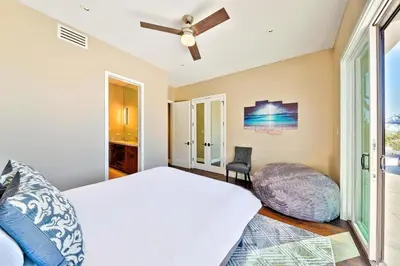 a bedroom with a bed and a ceiling fan at Luxury Bird Rock Home with Private Pool, Hot Tub & Fire Pit! in San Diego