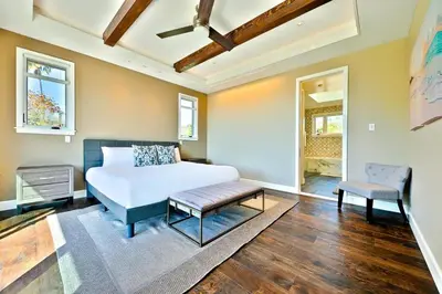 a bedroom with a bed and a table and a chair at Luxury Bird Rock Home with Private Pool, Hot Tub & Fire Pit! in San Diego