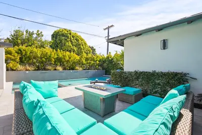 a patio with blue chairs and a table at Luxury Bird Rock Home with Private Pool, Hot Tub & Fire Pit! in San Diego