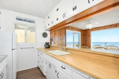 a kitchen with white cabinets and a large window at Upstairs 2 Bedroom Home with Ocean Views on 65th St in Newport Beach