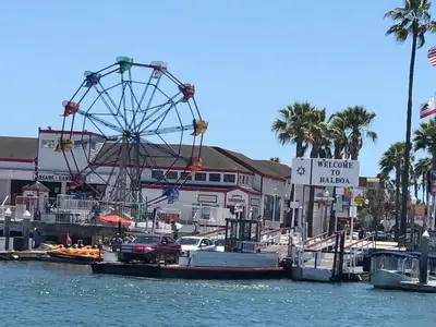 a ferris wheel and boats docked in a harbor at 2 Bedroom Oceanfront with Patio on the Boardwalk in Newport Beach