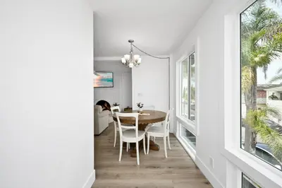 a dining room with white walls and a table and chairs at NEW - 3 Bedroom near the Balboa Pier and Fun Zone with AC in Newport Beach
