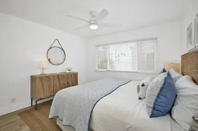 a white bedroom with a bed and a mirror at NEW - 3 Bedroom near the Balboa Pier and Fun Zone with AC in Newport Beach