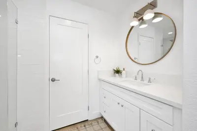 a white bathroom with a sink and a mirror at NEW - 3 Bedroom near the Balboa Pier and Fun Zone with AC in Newport Beach