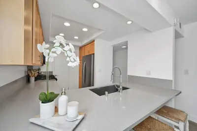 a kitchen counter with a sink and a vase with flowers at 6 Bedroom Duplex near the Balboa Pier and Fun Zone with AC in Newport Beach