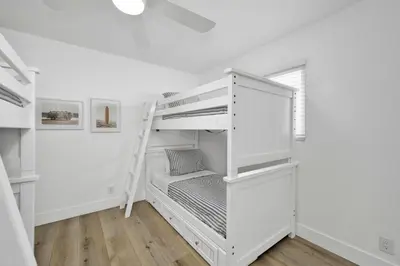 a white bunk bed with a ladder in a room at 6 Bedroom Duplex near the Balboa Pier and Fun Zone with AC in Newport Beach