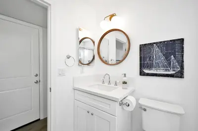 a white bathroom with a sink and a mirror at 6 Bedroom Duplex near the Balboa Pier and Fun Zone with AC in Newport Beach