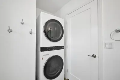 two washing machines in a room next to a door at 6 Bedroom Duplex near the Balboa Pier and Fun Zone with AC in Newport Beach
