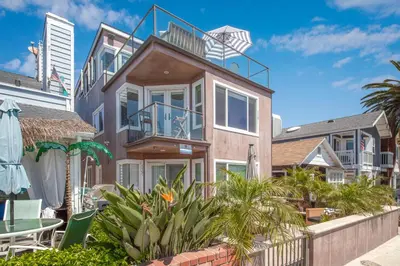 a house with a balcony and a patio at Luxury 3 Bedroom walk to Beach & Pier in Newport Beach
