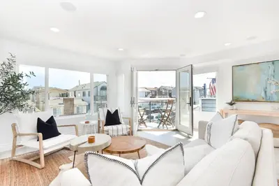 a living room with white furniture and large windows at Luxury 3 Bedroom walk to Beach & Pier in Newport Beach