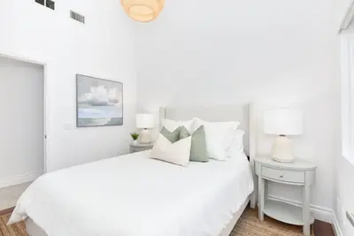 a white bedroom with a white bed with white pillows at Luxury 3 Bedroom walk to Beach & Pier in Newport Beach