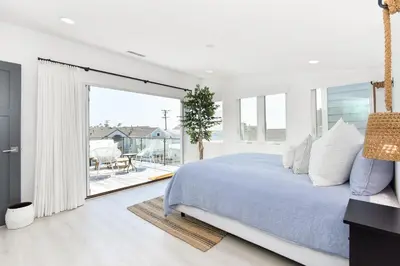 a bedroom with a large bed and a balcony at Luxury 3 Bedroom walk to Beach & Pier in Newport Beach