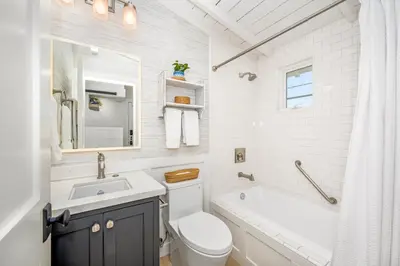 a bathroom with a sink and a toilet and a tub at Balboa Island Luxury Penthouse Suite With Bay Views in Newport Beach