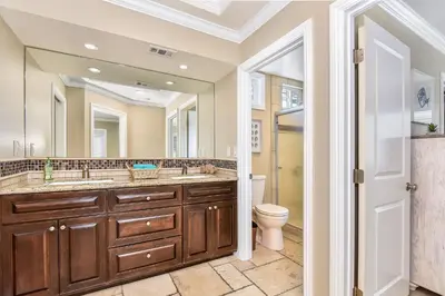 a bathroom with two sinks and a toilet and a mirror at 1 House from the Sand with Rooftop Deck on 28th Street in Newport Beach