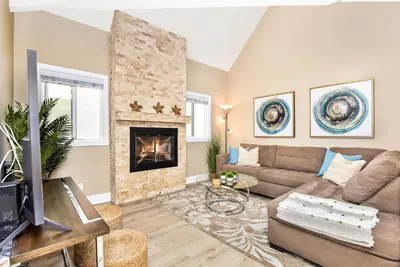 a living room with a couch and a fireplace at 1 House from the Sand with Rooftop Deck on 28th Street in Newport Beach