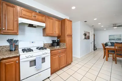 a kitchen with wooden cabinets and a white stove top oven at 6 Bedroom home located 2 houses in from the Beach in Newport Beach