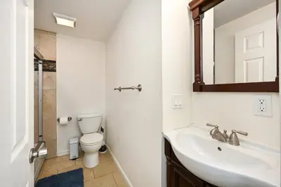 a bathroom with a sink and a toilet and a mirror at 6 Bedroom home located 2 houses in from the Beach in Newport Beach
