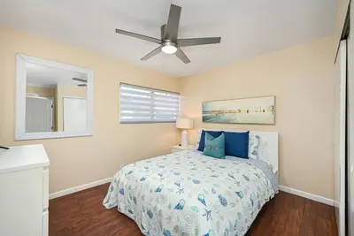 a bedroom with a bed and a ceiling fan at 6 Bedroom home located 2 houses in from the Beach in Newport Beach