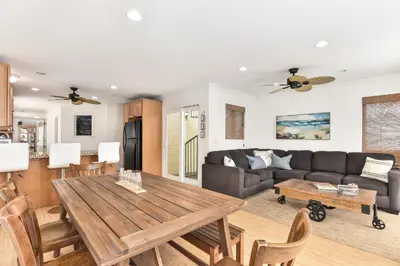 a living room with a table and a couch at 7 Bedroom Duplex Home with Rooftop & Peek-A-Boo Ocean View in Newport Beach