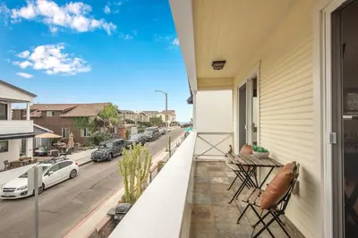 a balcony with chairs and a view of a street at 7 Bedroom Duplex Home with Rooftop & Peek-A-Boo Ocean View in Newport Beach